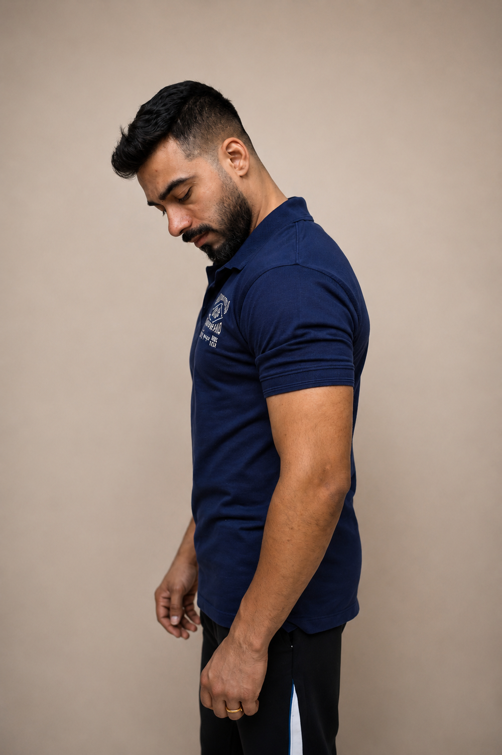 Man wearing navy polo shirt, side profile, regular fit