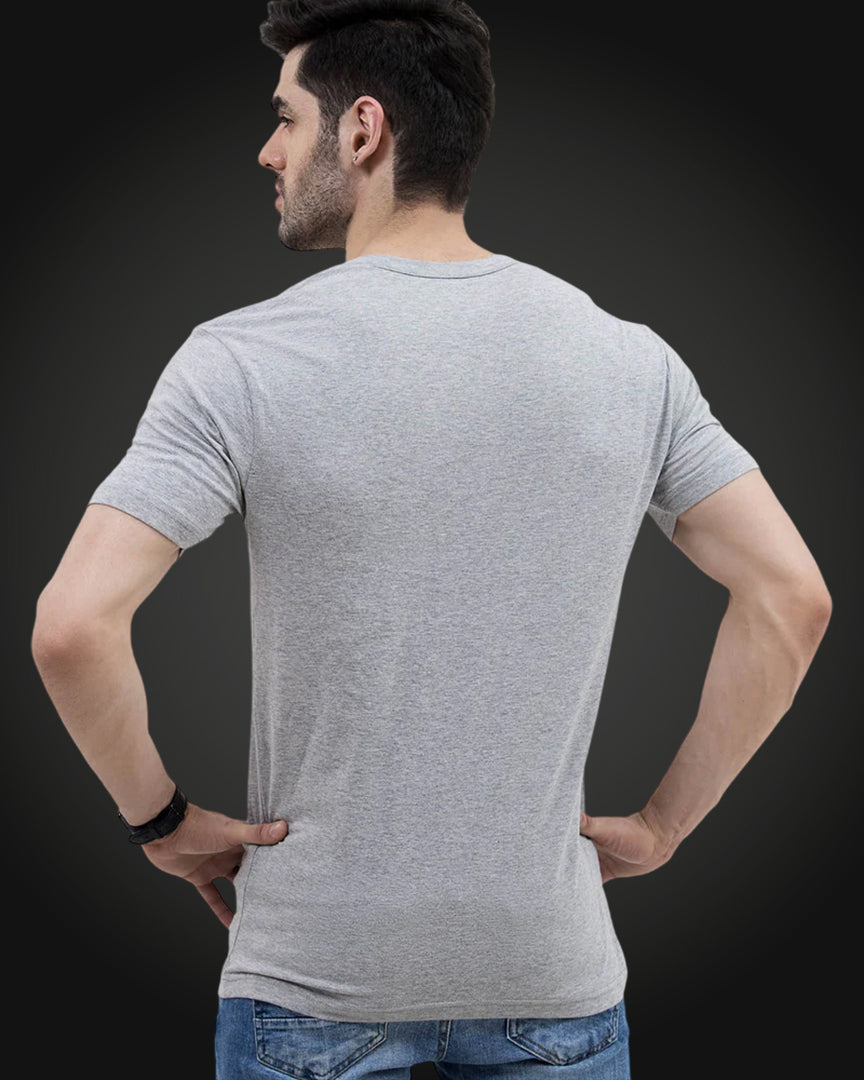 Man in grey round neck t-shirt, hands on hips studio shot