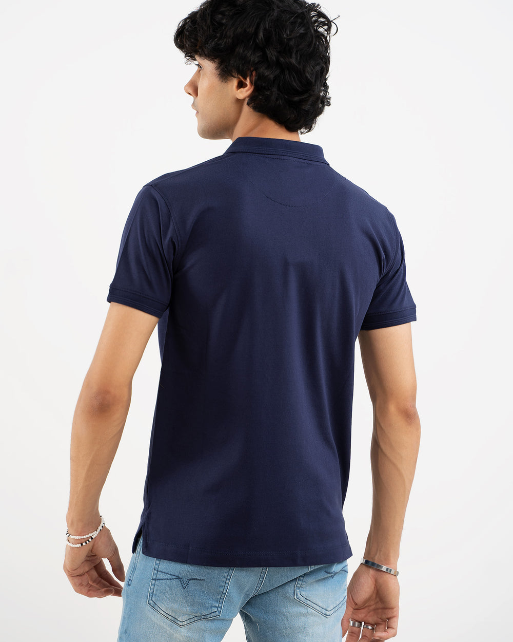 Man in navy blue polo shirt, back view