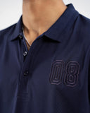 Close-up of navy blue polo shirt with tonal embroidered outlined "08" number on chest
