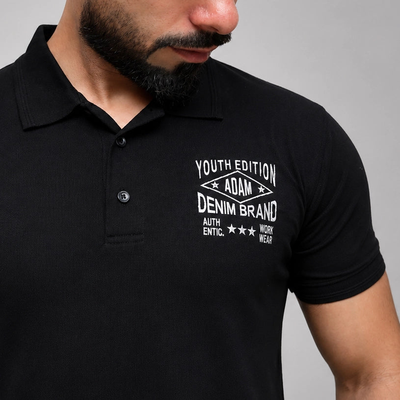 Black polo shirt with embroidered chest detail, close-up view