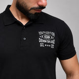 Black polo shirt with embroidered chest detail, close-up view