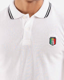 White polo shirt, black-green tipped collar, close-up of collar and crest logo, white bg