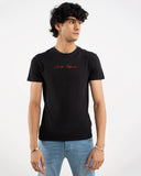 Man in black t-shirt with red "Living Legends" script signature print on chest, front view